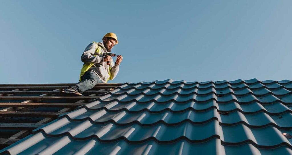 Professional roofer drilling modern roof