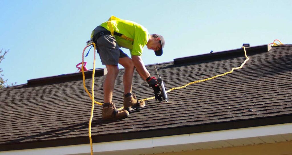 Professional roofer repairing modern roof