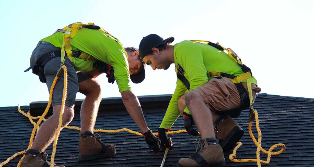 Two professional roofers working on a roof